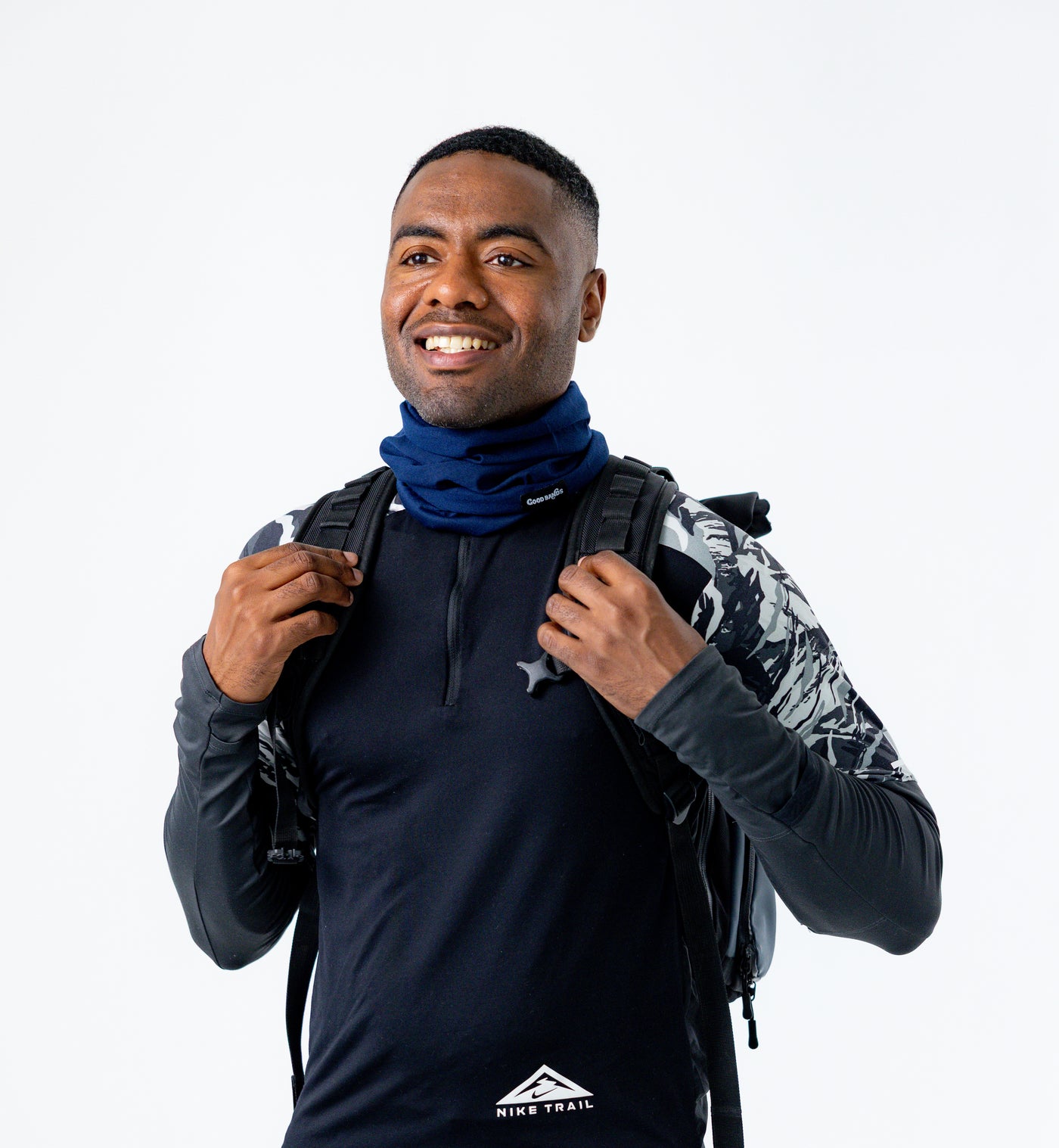 Runner wearing a navy neck gaiter with a running pack in cold weather