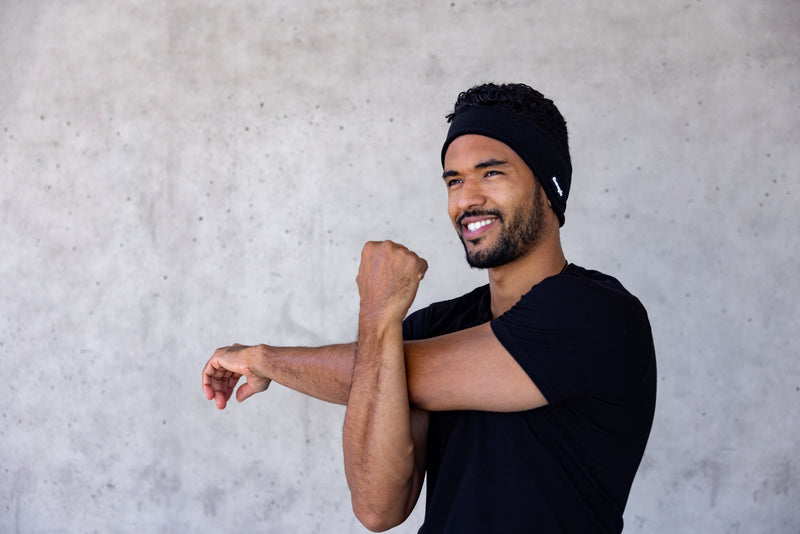 Black fleece ear warmer worn while stretching before a workout